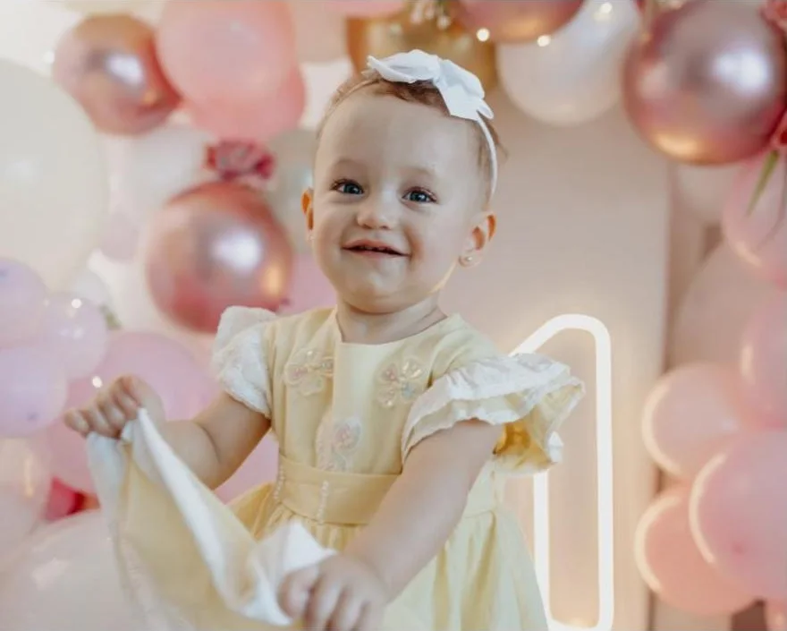 Menina de vestido amarelo sorrindo em ensaio de acompanhamento
